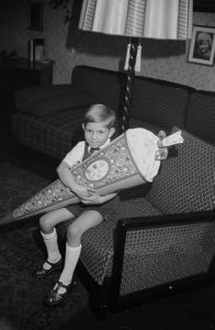 Black and white photograph of a young German boy holding a schultute or school cone for his first day of grade school