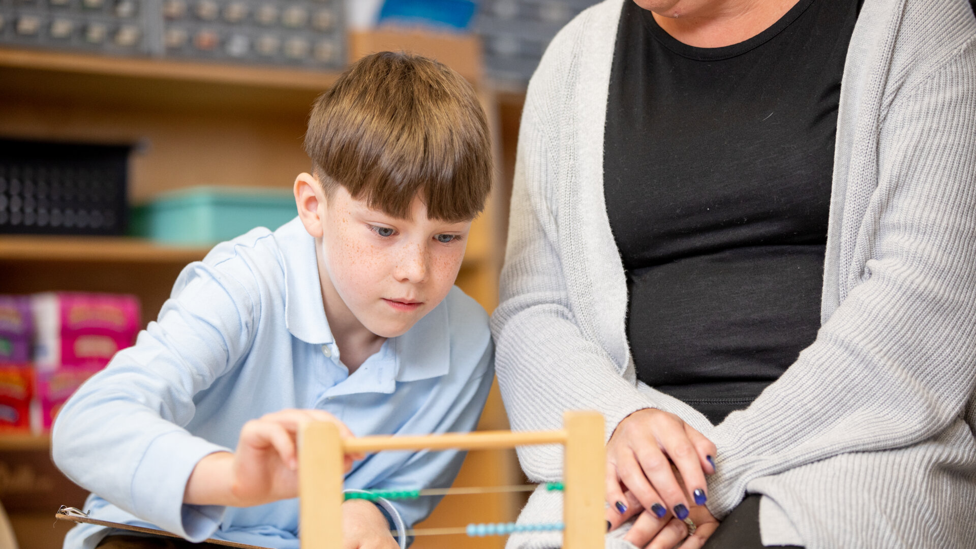 Creative Montessori Academy student learn to use an abacus for counting with instruction from her teacher.