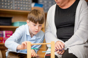 Creative Montessori Academy student learn to use an abacus for counting with instruction from her teacher.